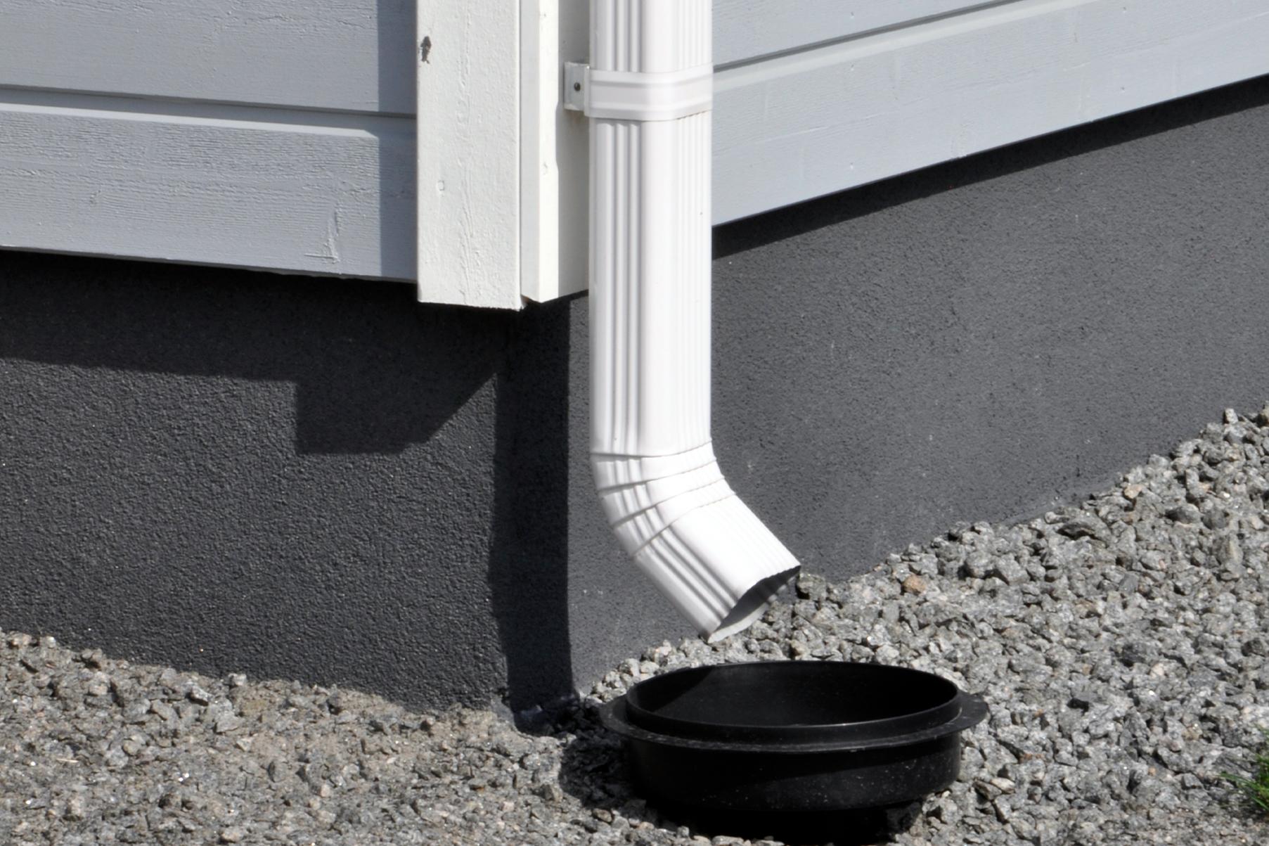 End pipe of the K-style rainwater system is correctly aimed at the rainwater drain. This prevents water from splashing into the house structures.